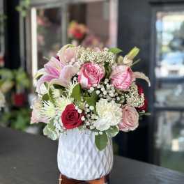 Pink and white mixed flower arrangement in a white vase