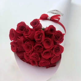 Heart-shaped bouquet of red roses with a red ribbon