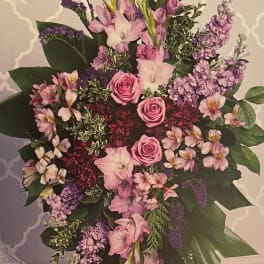 Large pink and purple floral standing spray with roses and lilies