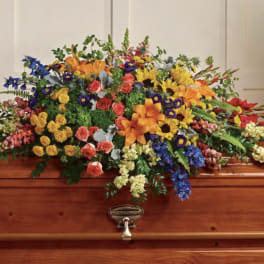 Colorful floral spray arranged on a wooden casket