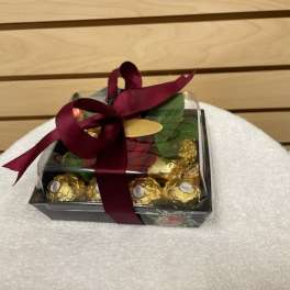 Gift box of chocolates tied with a burgundy ribbon