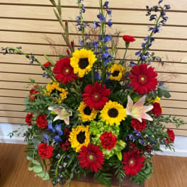 Tall mixed flower arrangement with sunflowers, red gerberas, and lilies