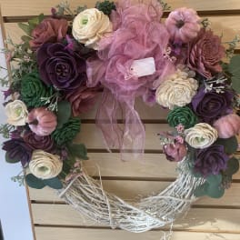 Heart-shaped floral wreath with pink ribbon and mixed blooms