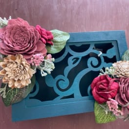 Decorative teal box with two floral clusters of pink and beige blooms