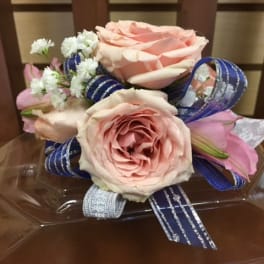 Pink roses with small white flowers and blue ribbon on a clear tray