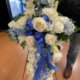 Tall white and blue floral standing spray with roses and lilies