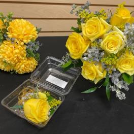 Yellow rose arrangements with yellow chrysanthemums and a clear plastic box