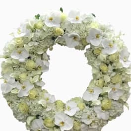 White floral wreath with orchids and pale green blooms