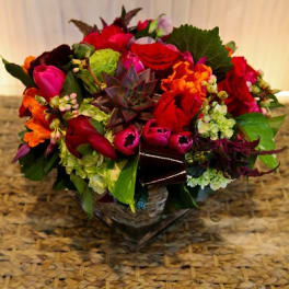 Colorful mixed flower arrangement in a low basket
