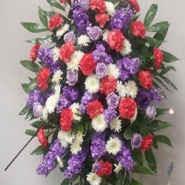 Standing floral spray with purple, red, and white flowers on an easel