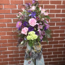 Tall mixed bouquet with pink and purple flowers in a decorative wrap