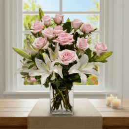 Pink roses and white lilies in a clear glass vase