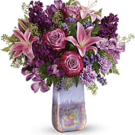 Pink and purple mixed bouquet in a tall iridescent vase