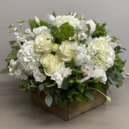 Low white and cream flower arrangement with roses and hydrangeas in a wooden box