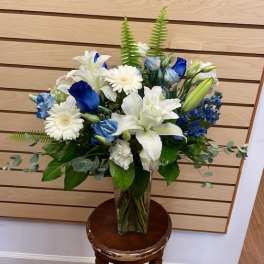 Blue and white floral arrangement in a clear glass vase
