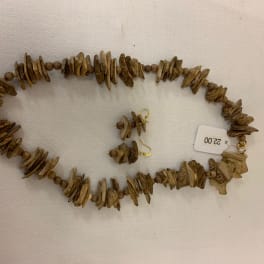 Brown beaded necklace and matching earrings on a white surface