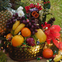 Fruit basket with pineapples, bananas, grapes, oranges, and a red bow