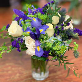 Bouquet of purple irises and white roses in a clear glass vase