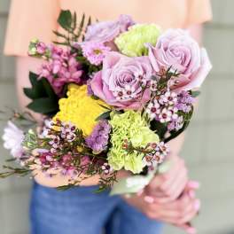 Handheld bouquet of pink and green flowers with yellow accents