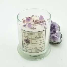 Lavender-scented candle in a glass jar with purple crystals beside it