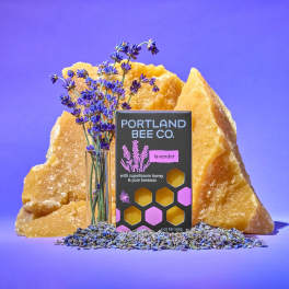 Lavender sprigs beside a lavender soap box and amber crystals