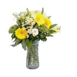 Yellow and white flower bouquet in a clear glass vase