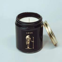 Black candle jar with a gold lid and Egyptian-style label