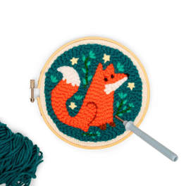 Embroidery hoop with a fox design and a needle tool