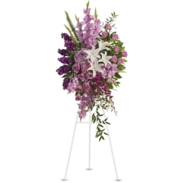 Tall standing spray of purple and white flowers on a white easel