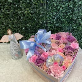 Heart-shaped box of pink and purple roses with a blue ribbon