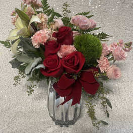 Bouquet of red and pink roses with lilies in a glass vase