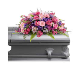 Pink and purple floral casket spray on a gray casket