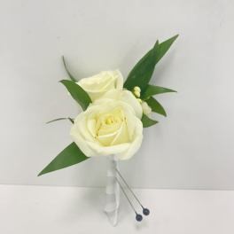 White rose boutonniere with greenery and wrapped stem on a white background