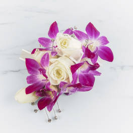 Corsage of white roses and bright pink orchids with ribbon and crystal accents