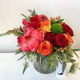 Red and pink floral arrangement in a glass vase