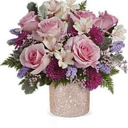 Pink roses and purple flowers arranged in a glittery vase