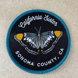Round California Sister patch with a butterfly design and text
