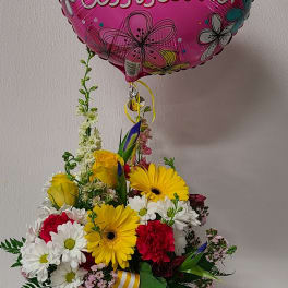 Bouquet in a glass vase with a pink balloon reading "Great Assistant!"