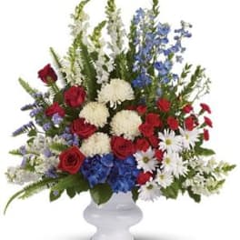Red, white, and blue floral arrangement in a white vase