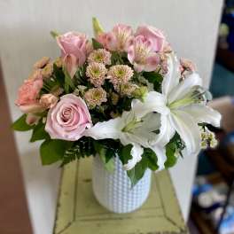 Pink roses and white lilies in a white vase