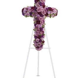 Purple floral cross on a white stand