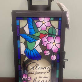 Decorative memorial lantern with floral stained-glass panels and a handle