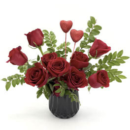 Red roses in a black vase with two glitter heart picks