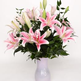 Pink lilies arranged in a lavender vase