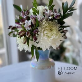 White chrysanthemums and purple alstroemeria in a white vase