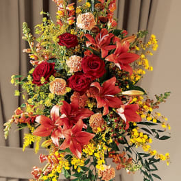 Tall floral spray with red lilies, roses, and yellow filler flowers