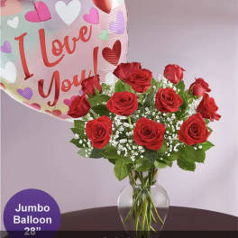Red roses in a glass vase with a heart-shaped "I Love You" balloon