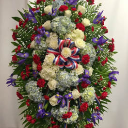 Large standing floral wreath with roses, hydrangeas, and purple irises