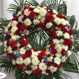 Large red, white, and blue floral wreath with palm fronds