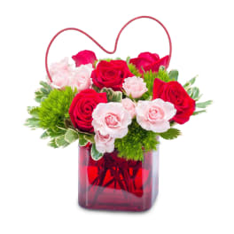 red container with red and pink roses topped with a heart